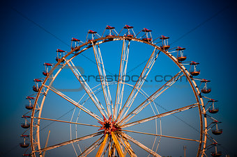 big wheel with multicolored cabins in amusement park 