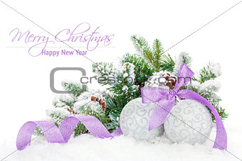 Christmas baubles and purple ribbon with snow fir tree