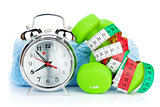 Two green dumbells, tape measure and alarm clock