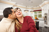 Mixed Race Couple Kissing Inside Beautiful Custom Kitchen