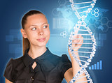 Beautiful woman in dress pointing finger on DNA model