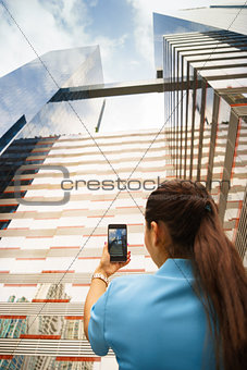 Person shooting photo of office building with telephone
