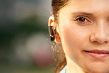 Business woman with phone bluetooth headset smiling