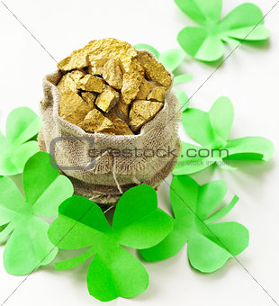 green clover leaves and a bag of gold - symbol of St. Patrick's Day