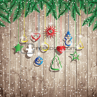 Fir tree branches and hanging toys on the wooden board background.
