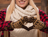 Woman in gloves show love sign