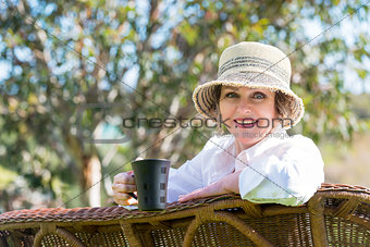 Smiling woman  with cup in the garden