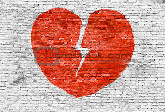 Broken heart painted on brick wall