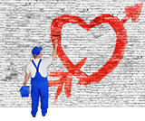 Heart and arrow painted on brick wall by man