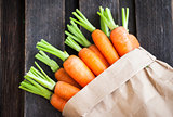 Fresh organic carrots in a paper bag