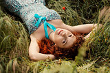 Beautiful redhead woman lying on grass