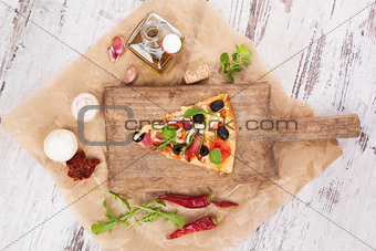 Pizza piece and pizza ingredients.