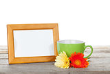 Photo frame with cup of coffee and gerbera flowers