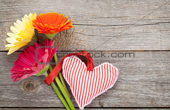 Colorful gerbera flowers and Valentine's day heart toy