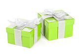 Two green gift boxes with silver ribbon and bow