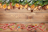 Christmas wooden background with fir tree, spices, gingerbread cookies