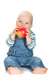 Small baby boy eating an apple