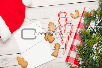 Christmas greeting card, santa hat, gingerbread cookies and snow