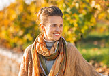 Happy young woman in autumn outdoors looking on copy space