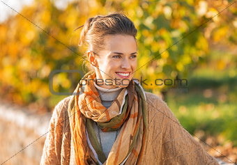Happy young woman in autumn outdoors looking on copy space