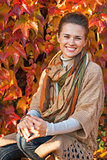 Portrait of smiling young woman in front of autumn foliage