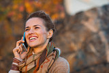 Portrait of happy young woman in autumn evening outdoors talking