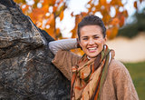 Portrait of smiling young woman in autumn outdoors in evening