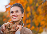 Portrait of happy young woman in autumn outdoors in evening