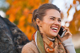 Portrait of happy young woman in autumn outdoors in evening talk