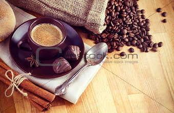 Cup hot coffee with beans and chocolate candies