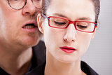 man hissing menaces in woman's ear