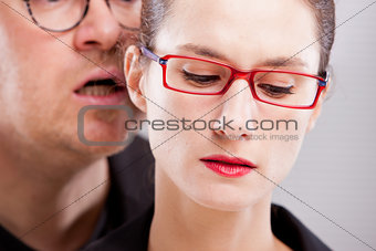 man hissing menaces in woman's ear