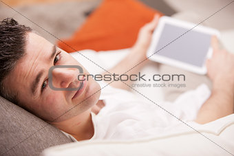relaxed man using a tablet at home
