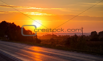 Orange sunset over asphalt road