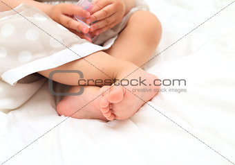baby girl in the dress playing their feet