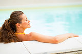 Profile portrait of relaxed young woman laying in pool