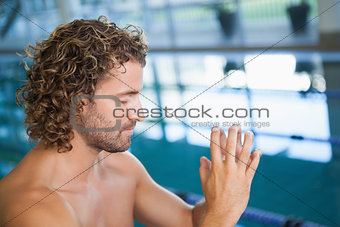 Close up side view of a shirtless fit swimmer by pool