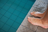 Close up low section of barefeet by pool