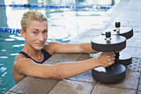 Female swimmer with foam dumbbells in swimming pool