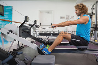 Side view of man using resistance band in gym