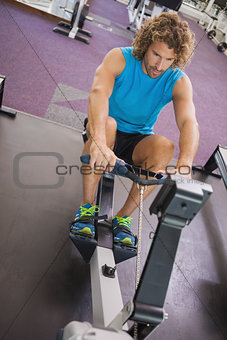Handsome young man using resistance band in gym
