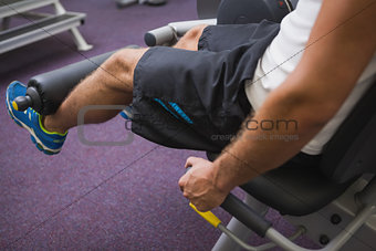 Side view of man doing leg workout at gym