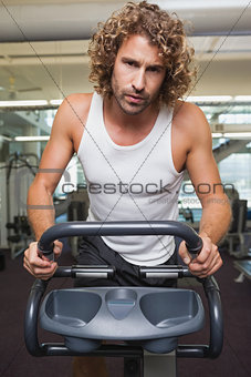 Fit man using exercise bike