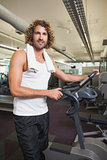Man standing by exercise bike at gym
