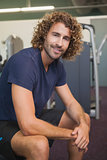 Portrait of a smiling handsome trainer in gym