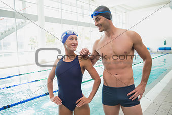 Fit couple swimmers by the pool at leisure center