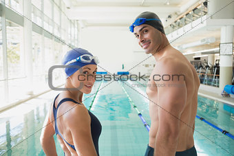 Fit couple swimmers by pool at leisure center