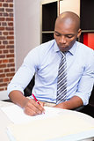 Businessman writing document at desk