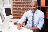 Portrait of businessman writing document at desk