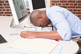 Businessman resting head on computer keyboard in office